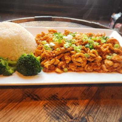 Spicy chicken stir-fry with scallions, served with white rice and broccoli