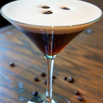 Espresso martini garnished with three coffee beans in a martini glass