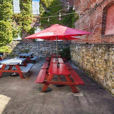 Outdoor patio at RameNesque with red picnic tables and a red umbrella